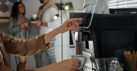 person using a coffee machine